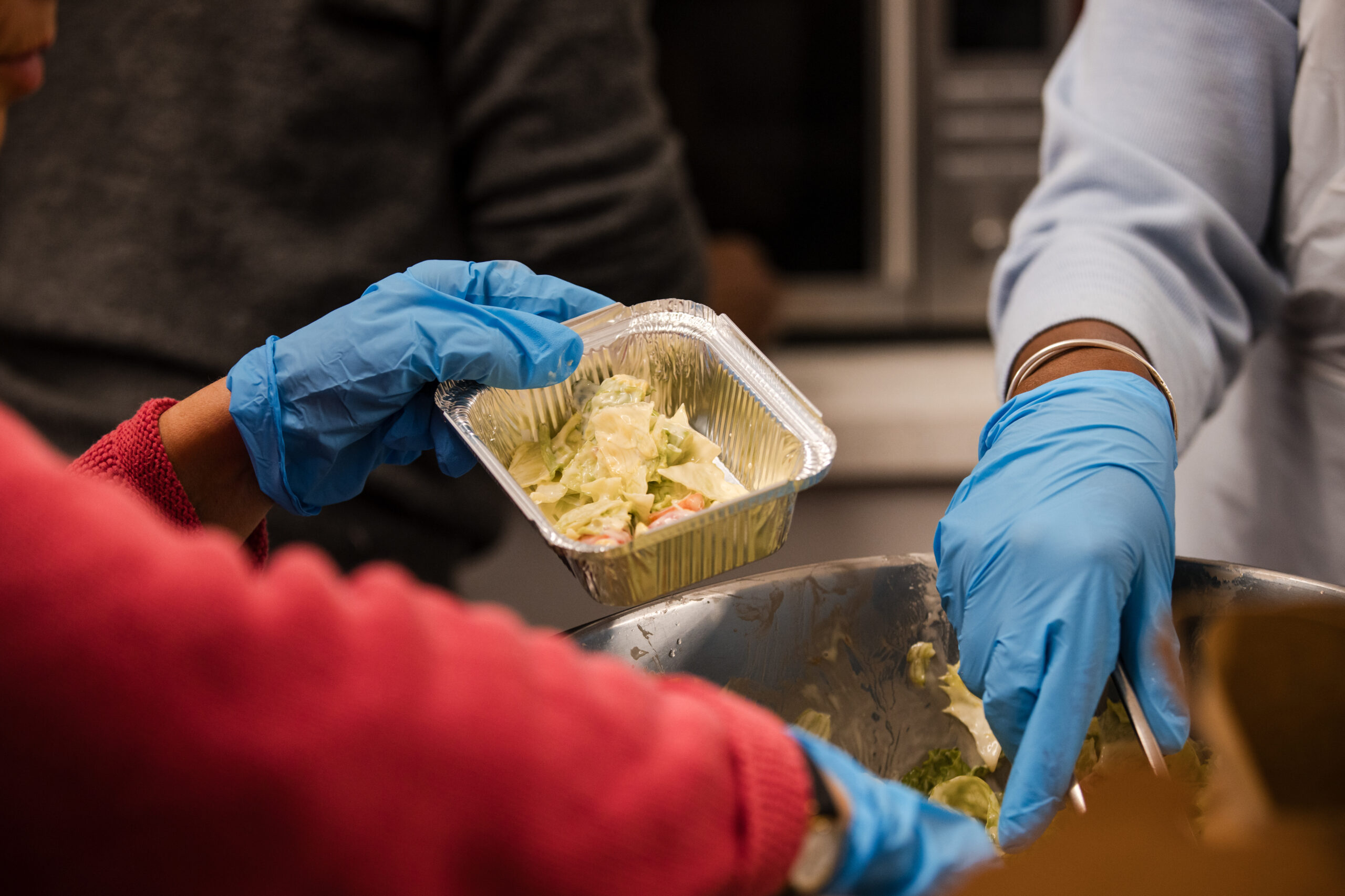 Christian Kitchen volunteers putting a salad in a takeaway box